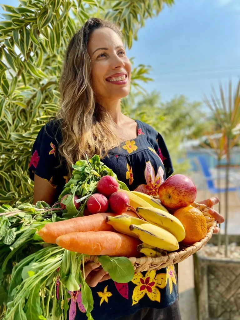 mulher com cesta de verduras praticando hábitos anticâncer com alimentação saudável